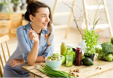 young happy woman eating healthy 260nw 622381814 e1650642475147