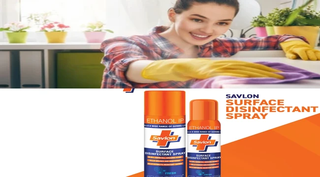 Beautiful young woman makes cleaning the house. Girl cleaning with savlon surface disinfectant spray.