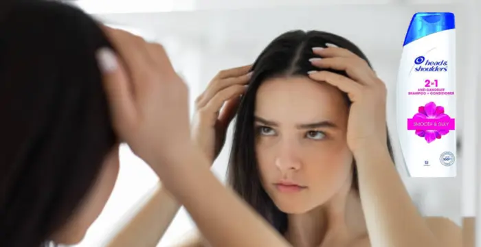 a woman see dandruff in her hair