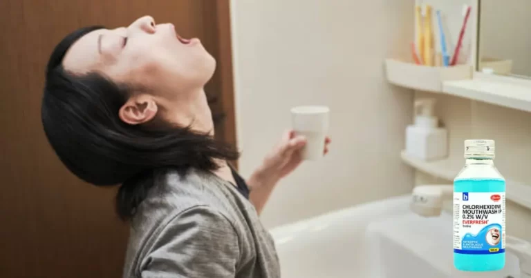 A woman in their bathroom using Chlorhexidine mouthwash ip