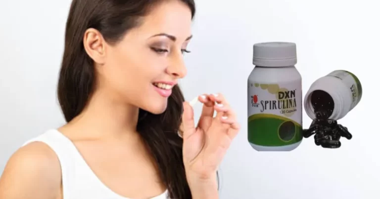 A lady taking a Dxn Spirulina Capsule in her hand for eat it